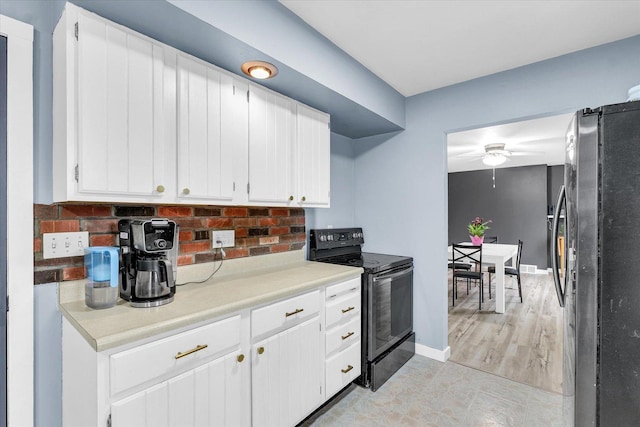 1695 Willowdale Dr, Saint Joseph, IL 61873 - kitchen with light countertops, freestanding refrigerator, black range with electric cooktop, and white cabinetry