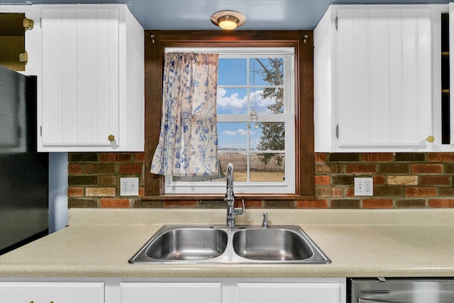 1695 Willowdale Dr, Saint Joseph, IL 61873 - kitchen featuring light countertops, stainless steel dishwasher, freestanding refrigerator, white cabinets, and a sink