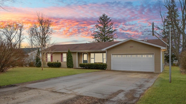 ranch-style home with a garage, driveway, and a front lawn