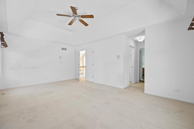 unfurnished room with light carpet, visible vents, a raised ceiling, baseboards, and ceiling fan