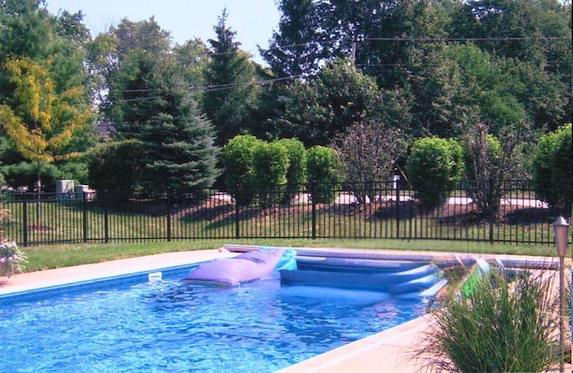 view of swimming pool with fence and a lawn