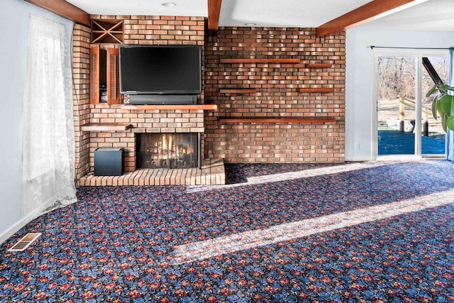 unfurnished living room featuring carpet, a fireplace, visible vents, brick wall, and beamed ceiling