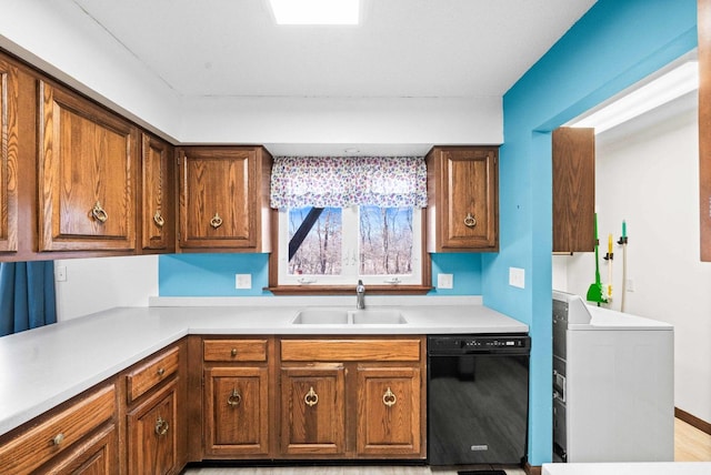 kitchen with brown cabinets, black dishwasher, light countertops, and a sink