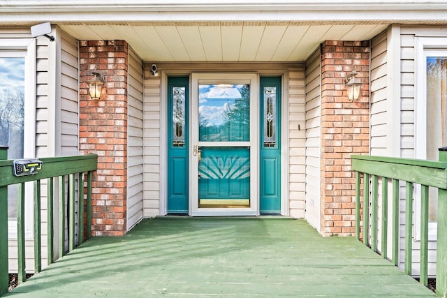 property entrance with covered porch and brick siding