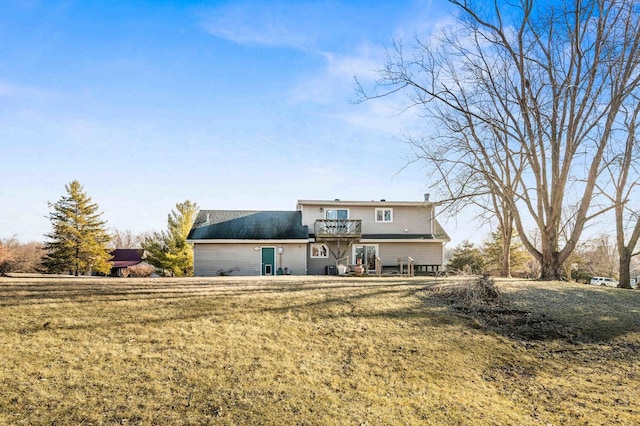 back of property featuring a yard and a balcony