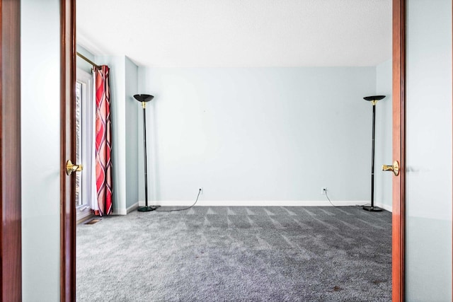 carpeted spare room with baseboards