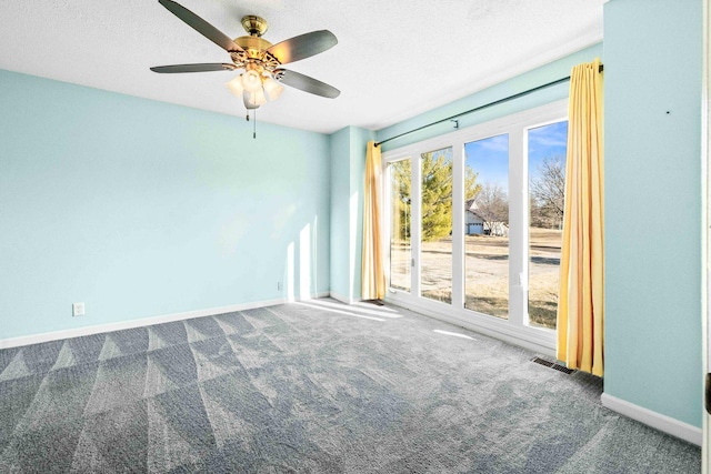 carpeted empty room featuring visible vents, ceiling fan, a textured ceiling, and baseboards