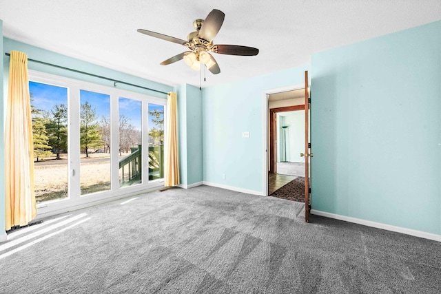 unfurnished room featuring carpet floors, ceiling fan, and baseboards