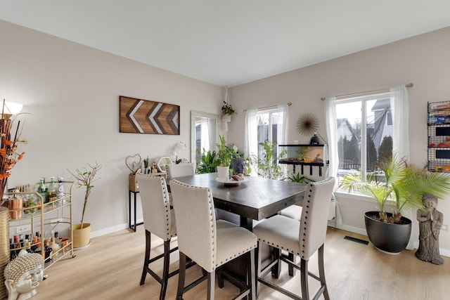 dining room with visible vents, light wood-style flooring, and baseboards