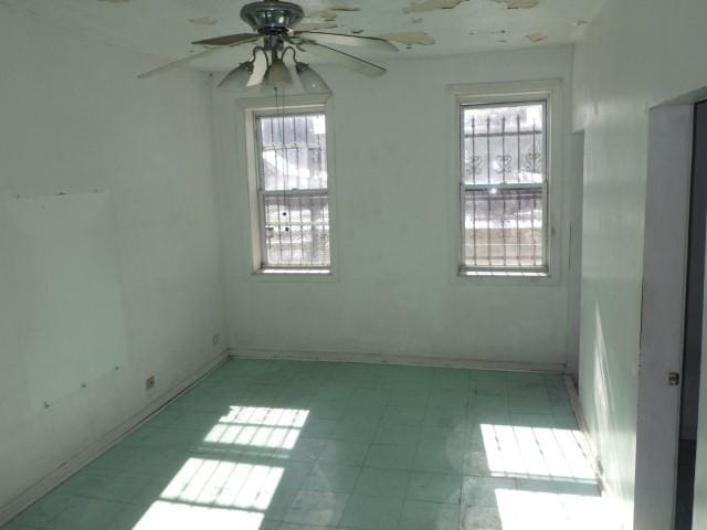 empty room featuring light floors and a ceiling fan