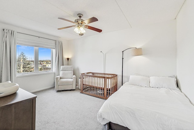 bedroom with light colored carpet, ceiling fan, and baseboards