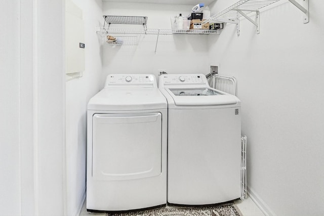 laundry area featuring washing machine and dryer, laundry area, and baseboards