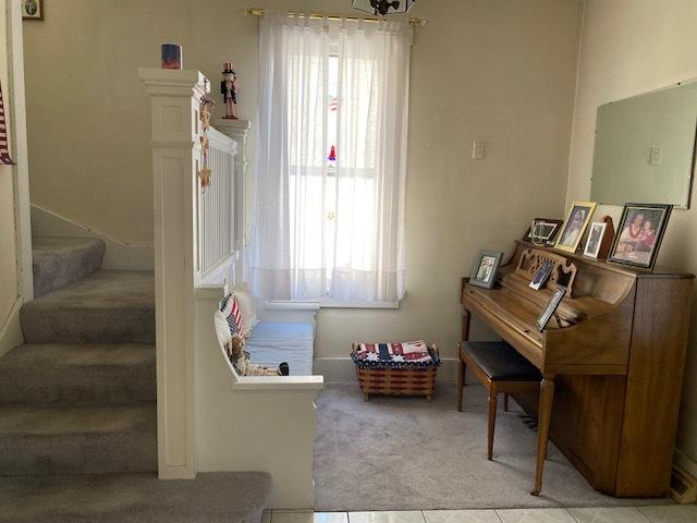 interior space with light colored carpet and light tile patterned flooring