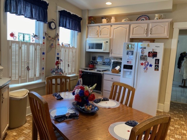 interior space with white cabinets, white appliances, and light countertops