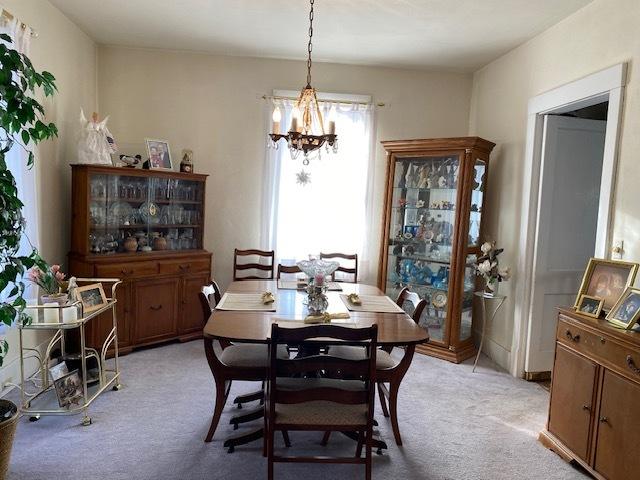 dining room featuring a chandelier and light colored carpet