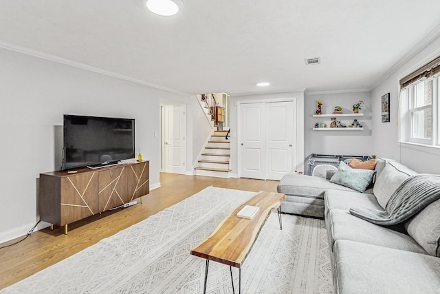 living area featuring baseboards, stairway, wood finished floors, and ornamental molding