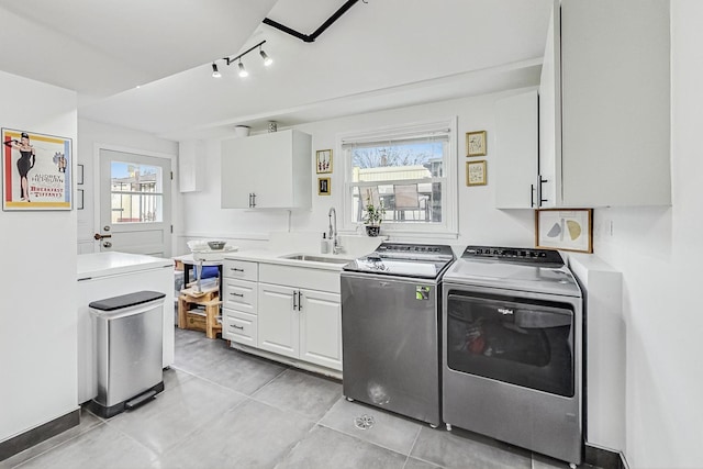 laundry area with washing machine and dryer, light tile patterned flooring, and a sink