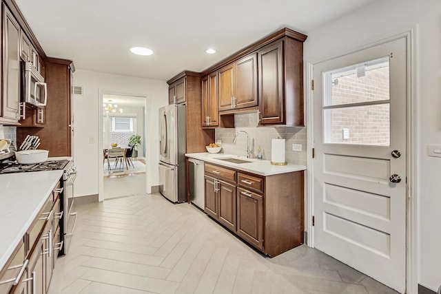 kitchen featuring a sink, visible vents, light countertops, appliances with stainless steel finishes, and decorative backsplash