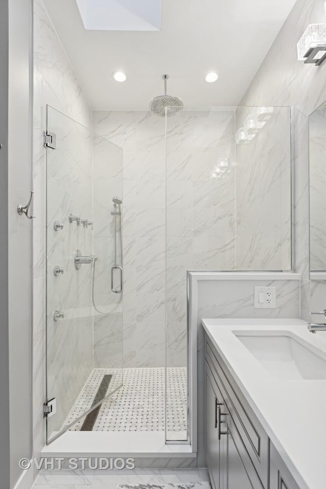 full bath with vanity, tile walls, recessed lighting, and a marble finish shower