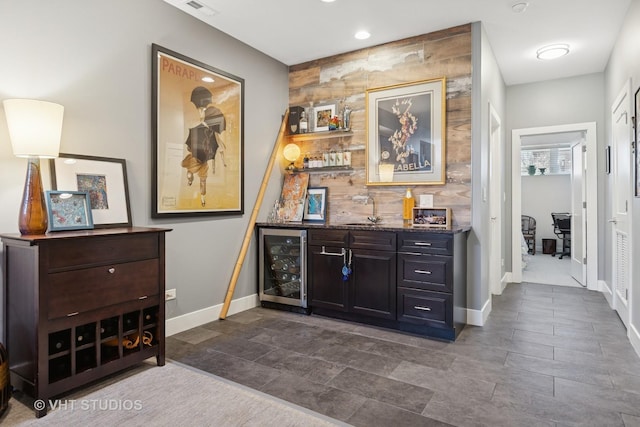 interior space with beverage cooler, baseboards, and a sink