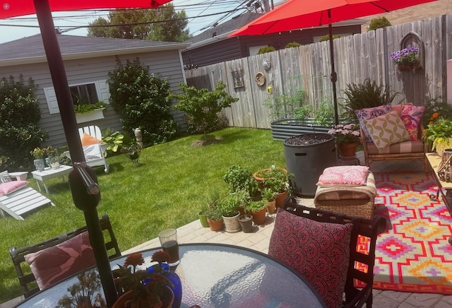 view of yard featuring a patio area, outdoor dining area, and fence