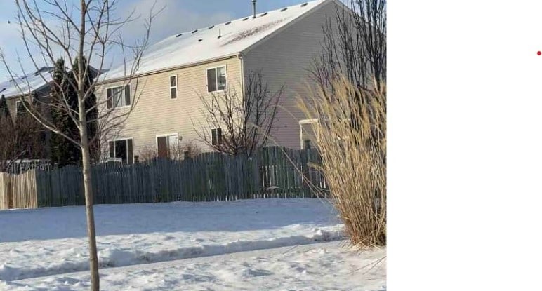 view of snowy exterior with fence