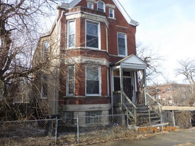 view of front of home with a fenced front yard and brick siding