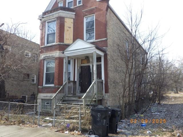 view of front of house featuring fence and brick siding