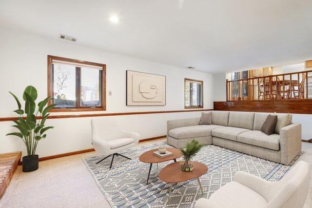 carpeted living room featuring visible vents and baseboards