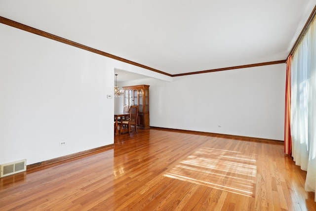 unfurnished room featuring ornamental molding, a chandelier, visible vents, and light wood finished floors