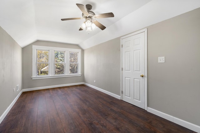 additional living space with vaulted ceiling, ceiling fan, dark wood-style flooring, and baseboards