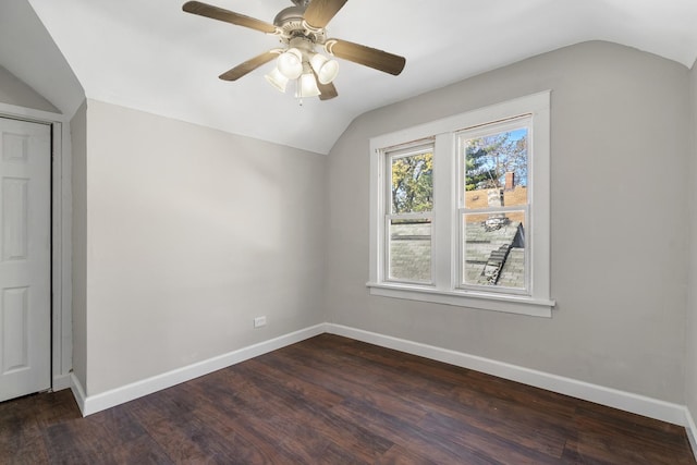 interior space with ceiling fan, baseboards, vaulted ceiling, and dark wood-style flooring