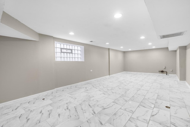 below grade area with recessed lighting, marble finish floor, visible vents, and baseboards