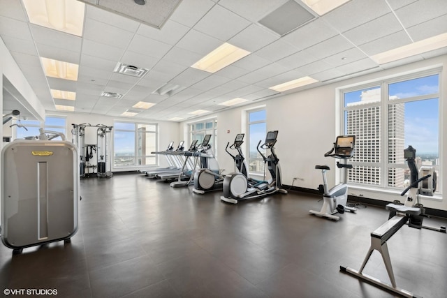 gym with a view of city, a drop ceiling, and visible vents