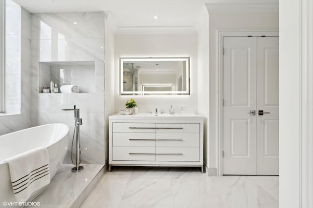 full bathroom featuring marble finish floor, ornamental molding, a freestanding tub, and vanity