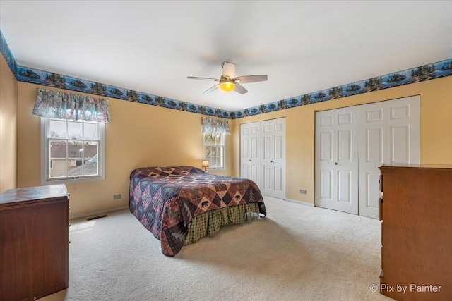 631 Alice Ct, Elgin, IL 60123 - carpeted bedroom featuring multiple windows, two closets, a ceiling fan, and baseboards