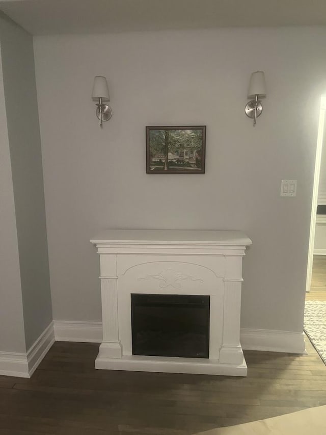 interior details with a fireplace, wood finished floors, and baseboards