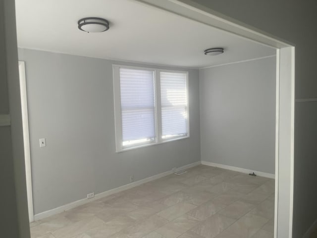 unfurnished room with visible vents and baseboards