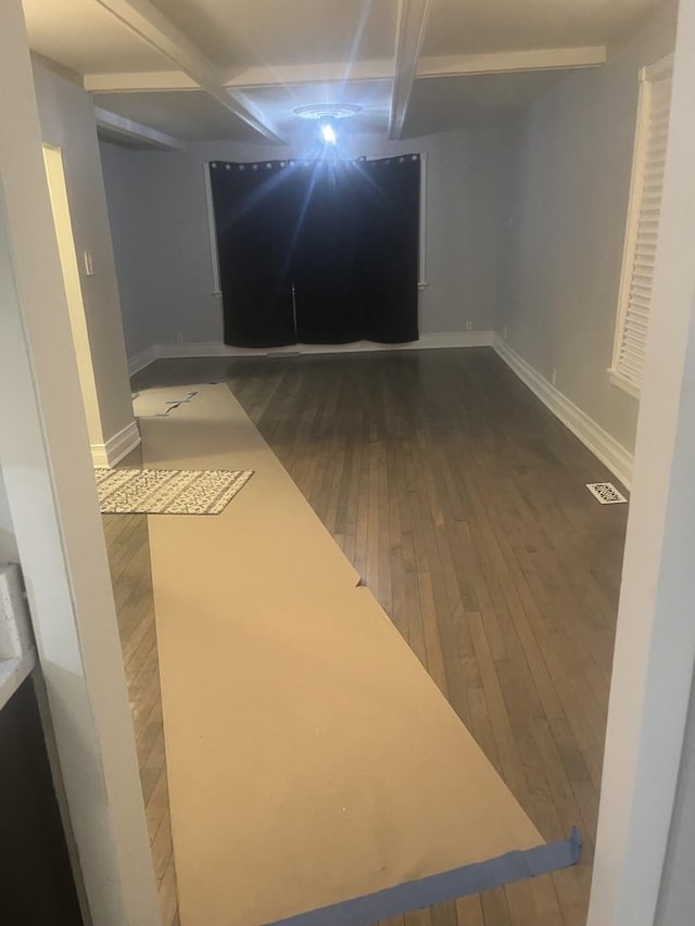 basement with visible vents, baseboards, and wood finished floors