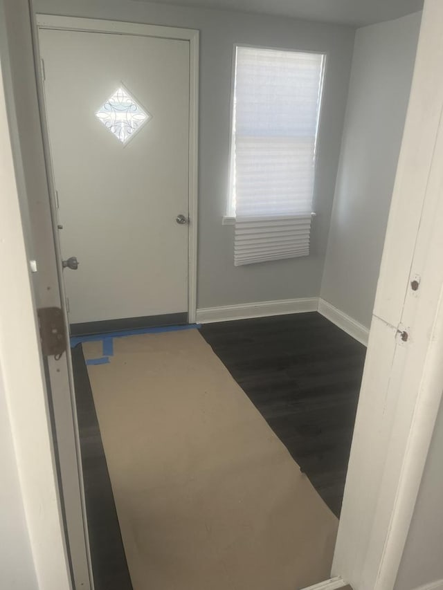 doorway to outside with dark wood-style floors and baseboards