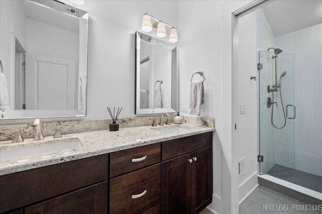 full bath with double vanity, a sink, visible vents, and a shower stall