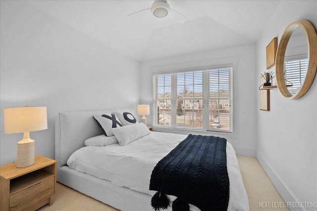 bedroom featuring vaulted ceiling, light colored carpet, and baseboards