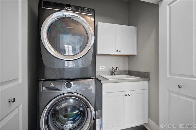 clothes washing area featuring a sink, cabinet space, and stacked washer / drying machine