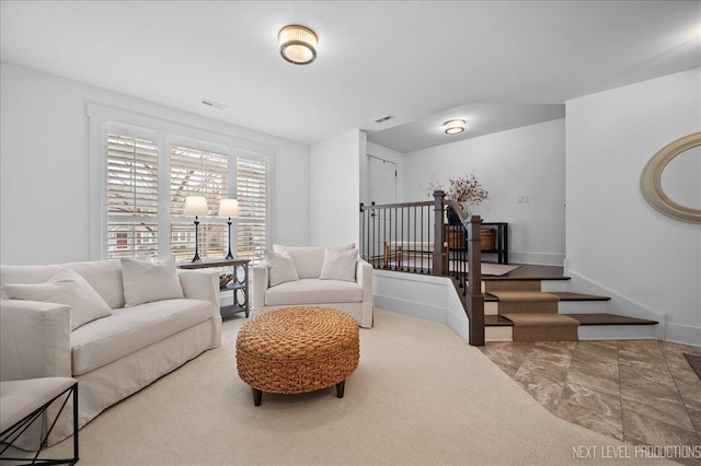 living area featuring stairs, visible vents, and baseboards