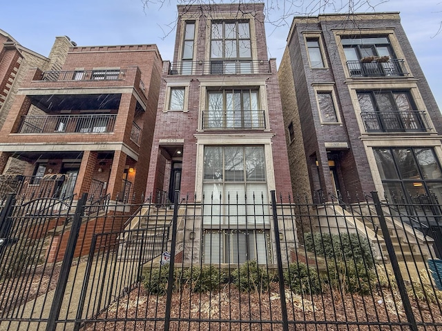 view of front facade with a fenced front yard and brick siding