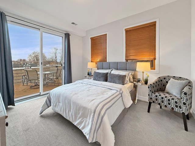 bedroom with access to outside, carpet, and visible vents