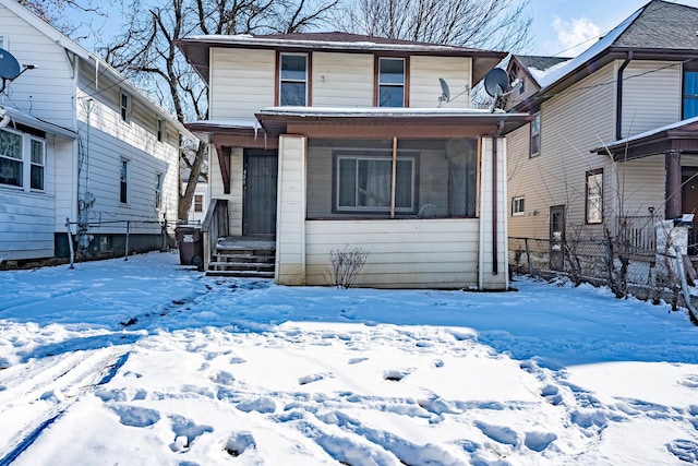 view of front of home featuring a sunroom and fence