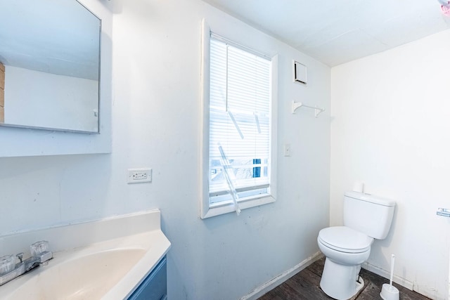 bathroom with toilet, baseboards, wood finished floors, and vanity