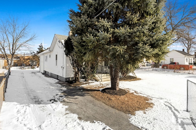 view of snow covered exterior with fence