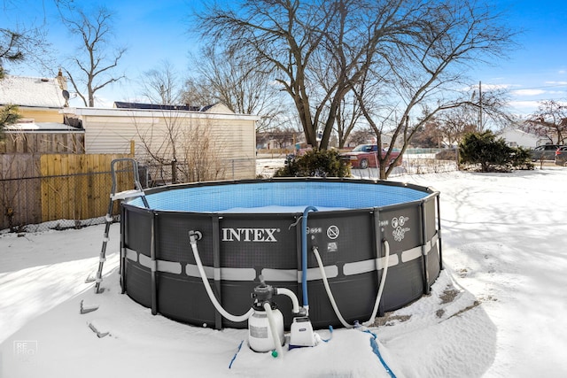 snow covered pool with an outdoor pool and fence